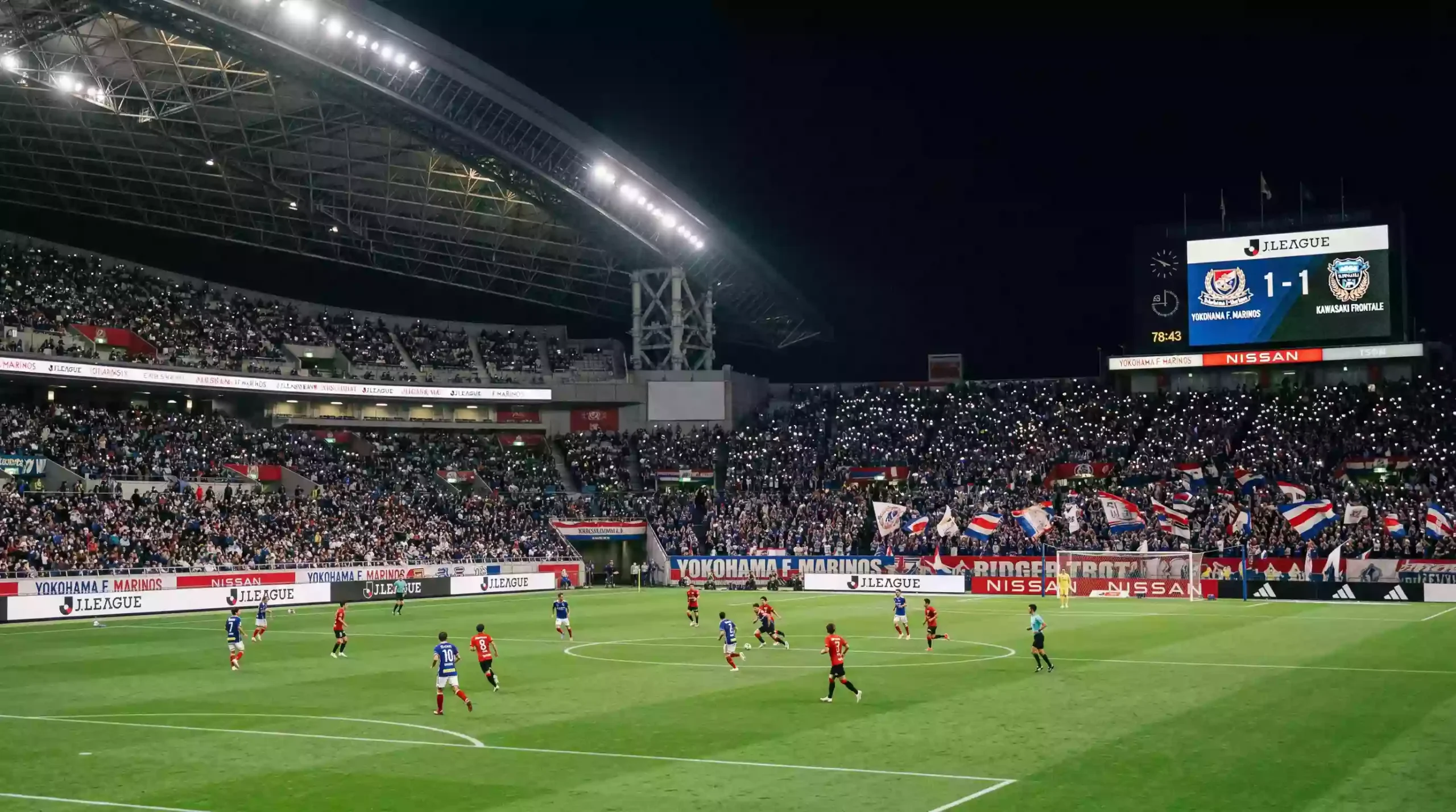 Partido nocturno de la J.League con iluminacion artificial y aficionados en las gradas